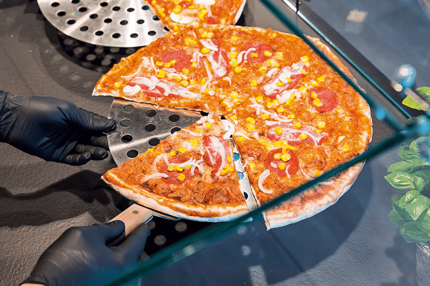 Pizza wird in einem Tankstellen Bistro zubereitet und serviert